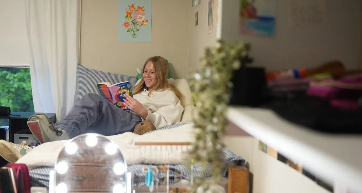 girl reading on bed in dorm room