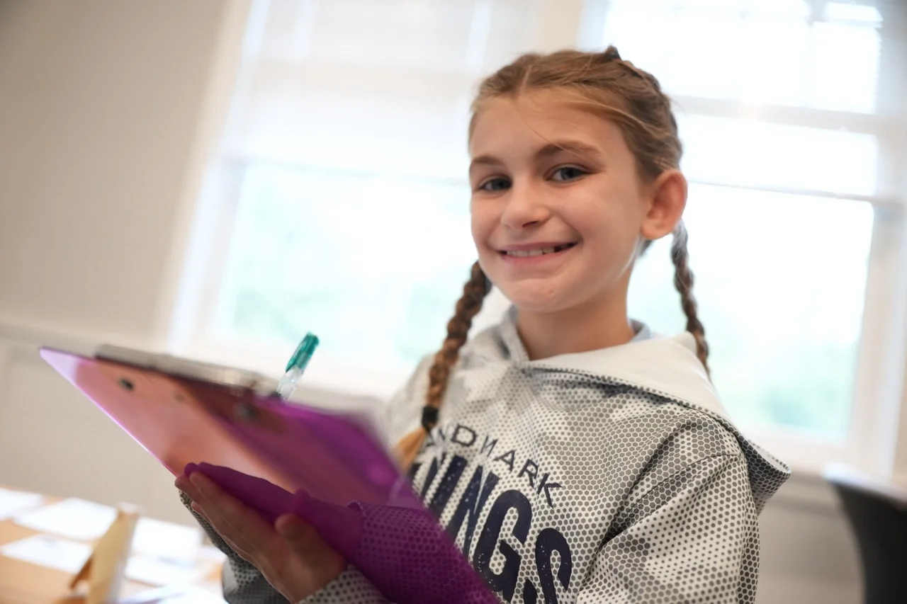 elementary girl smiling with clipboard