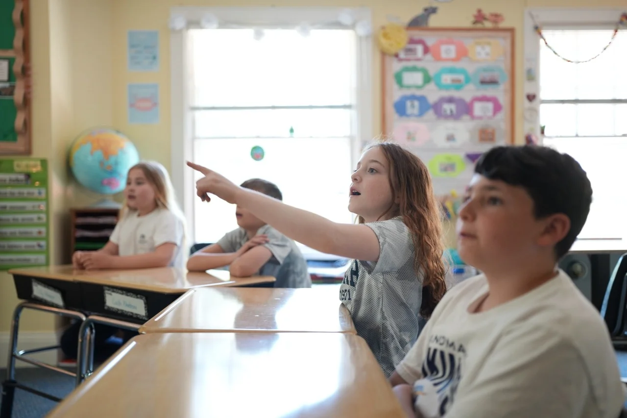 girl pointing in elementary classroom