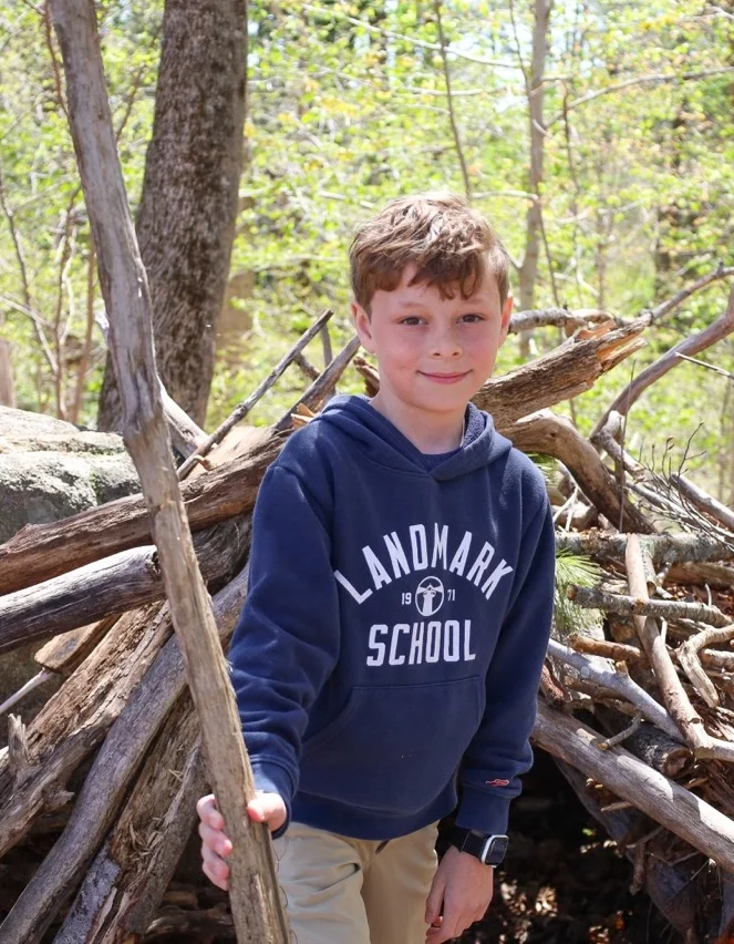 boy playing in woods near playground