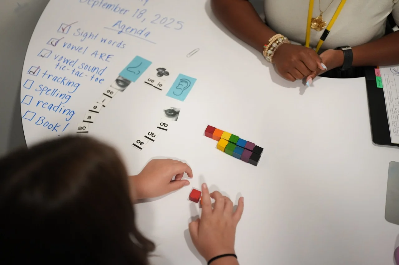 teacher and student working in tutorial with literacy blocks