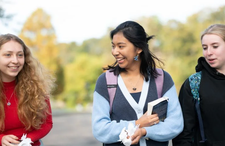 three girls walking and smiling together