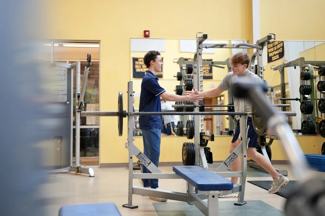 boys in weight room hand shaking