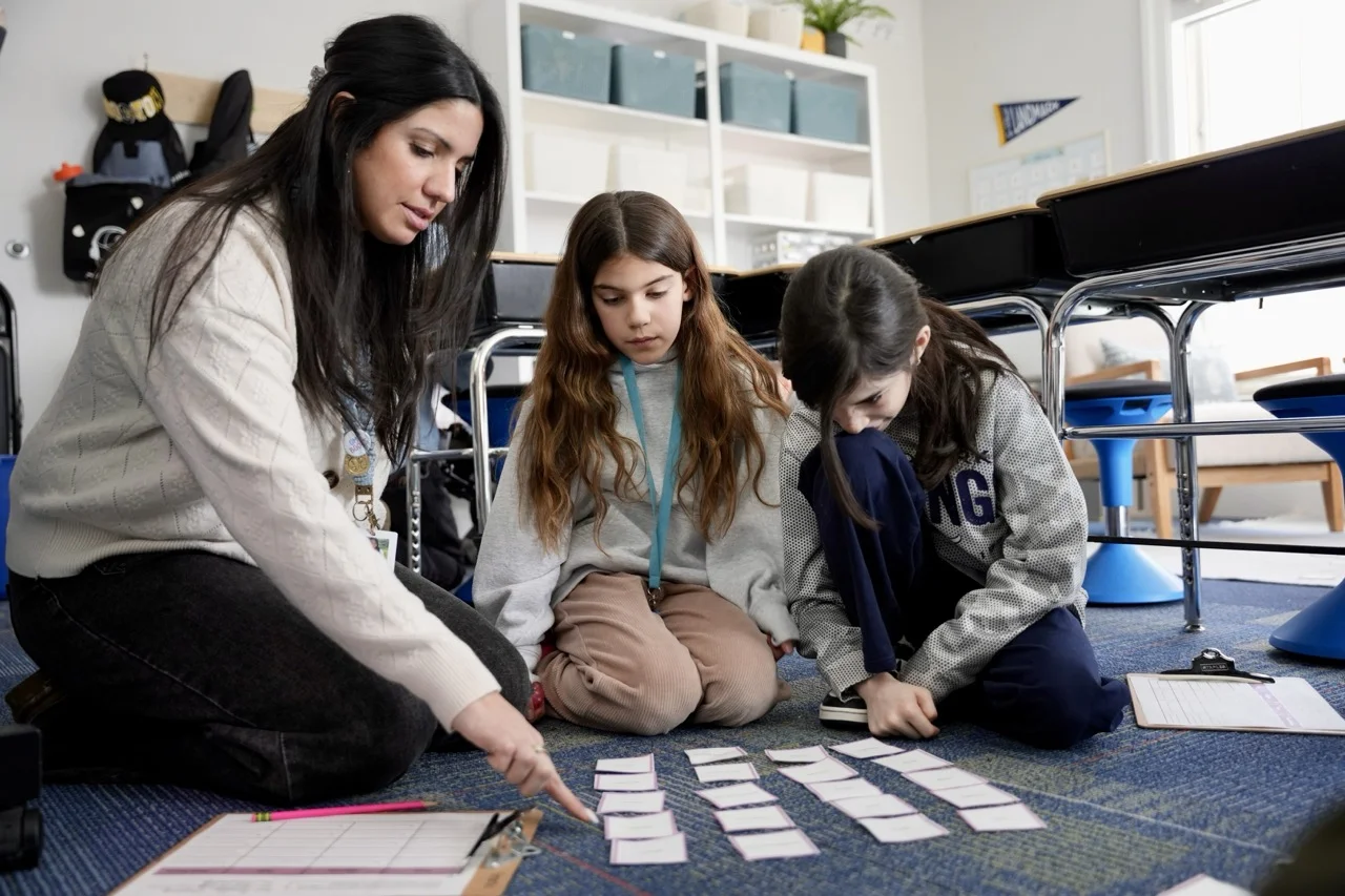 teacher helping two students build literacy skills through sorts and vocab building