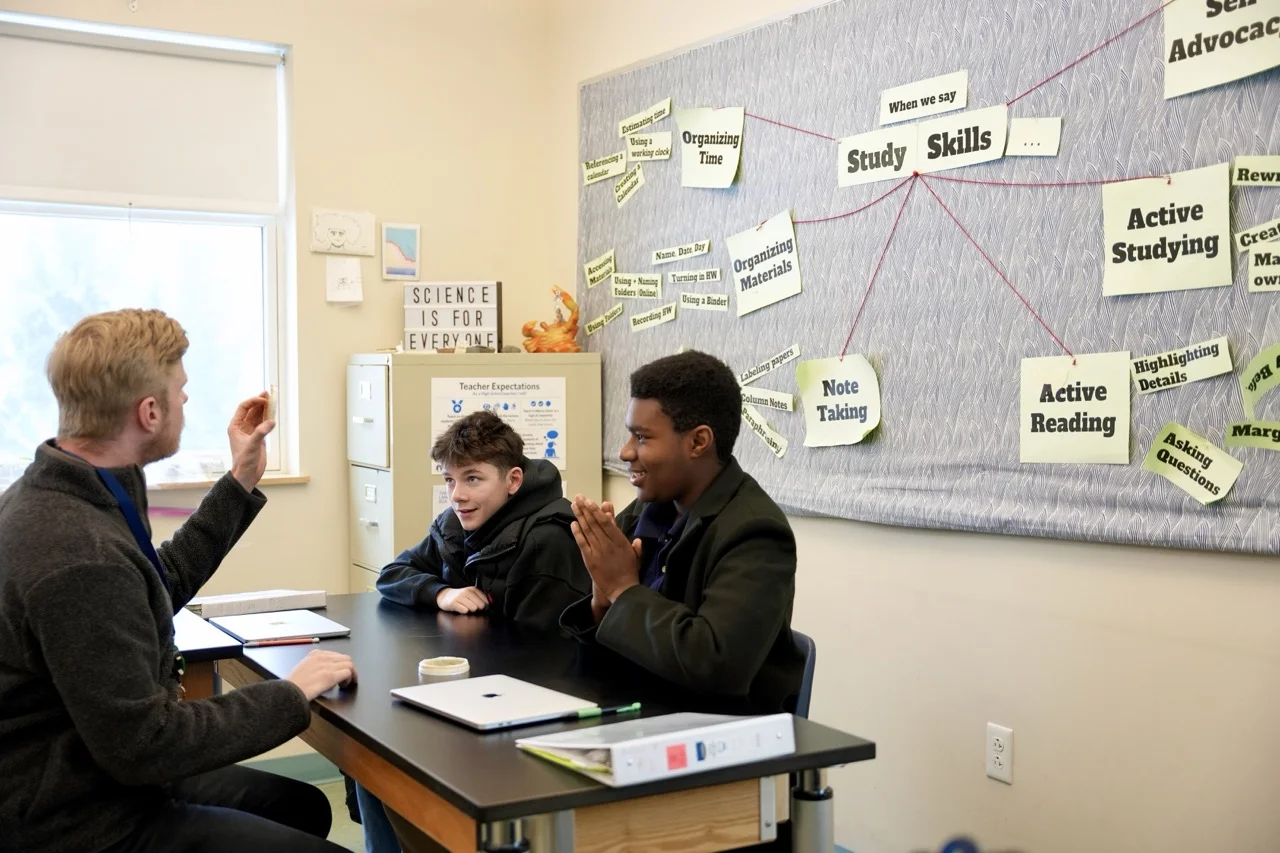 teacher with small class of high school students looking at biology hands on learning