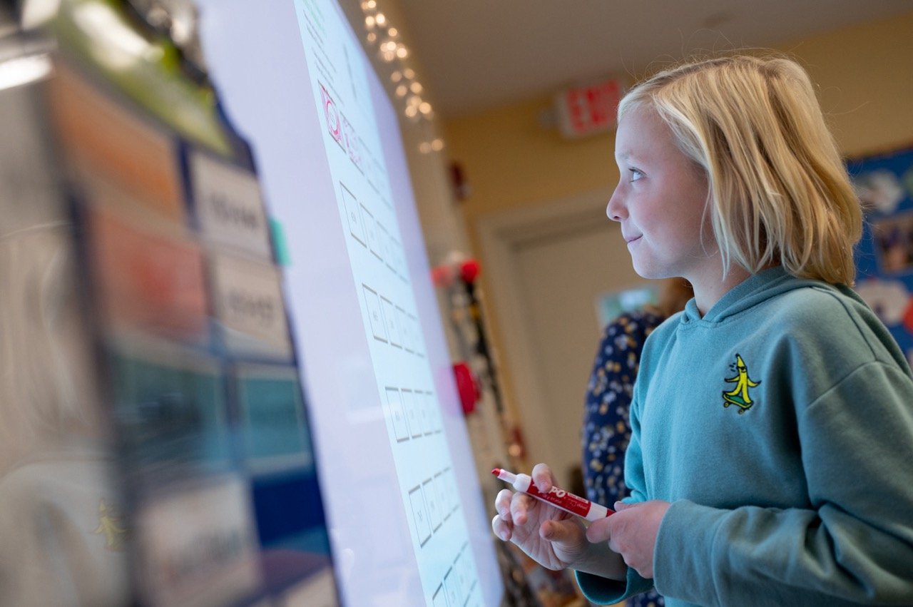 student solving problem at board