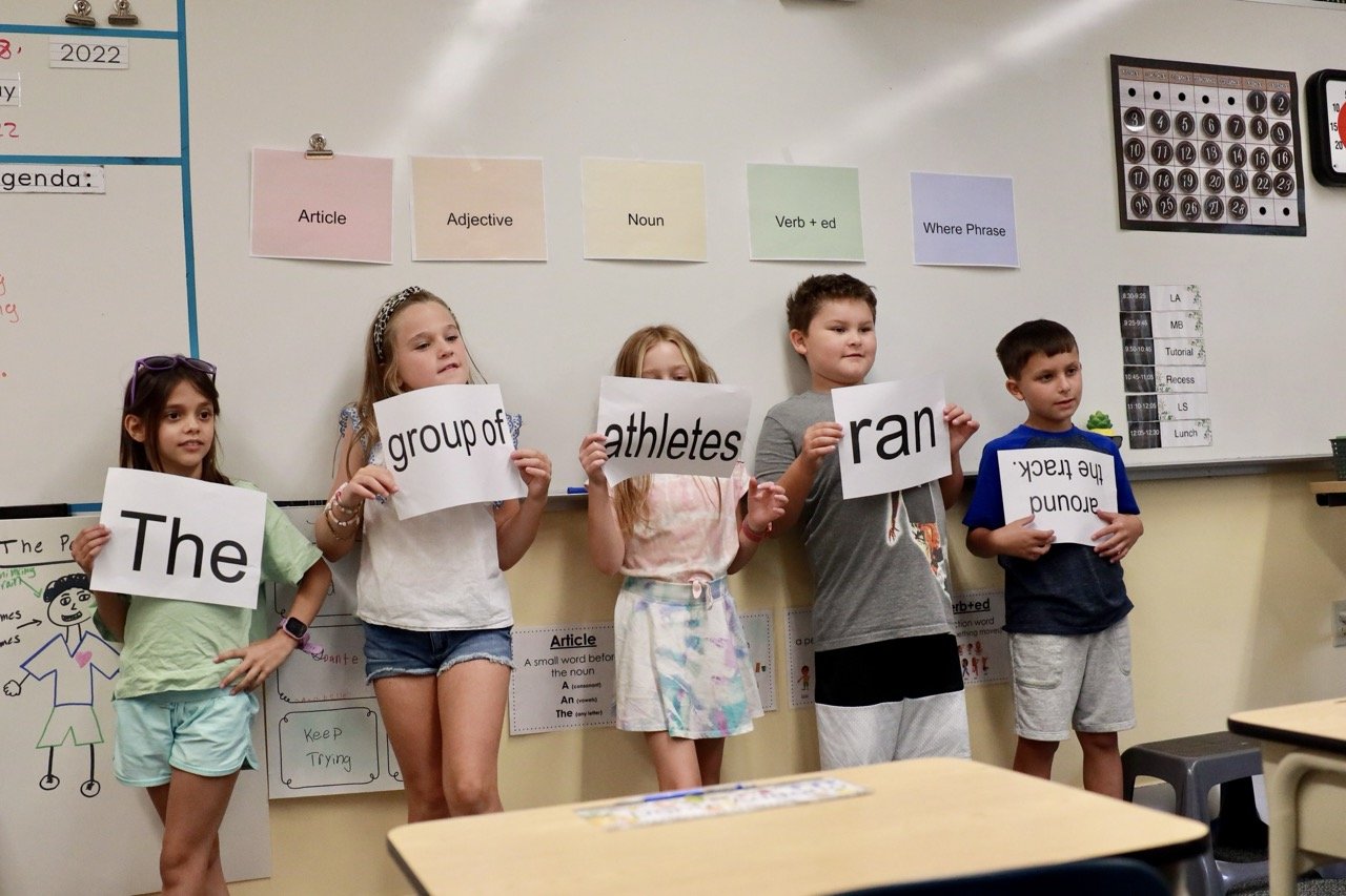 students building sentences at front of classroom