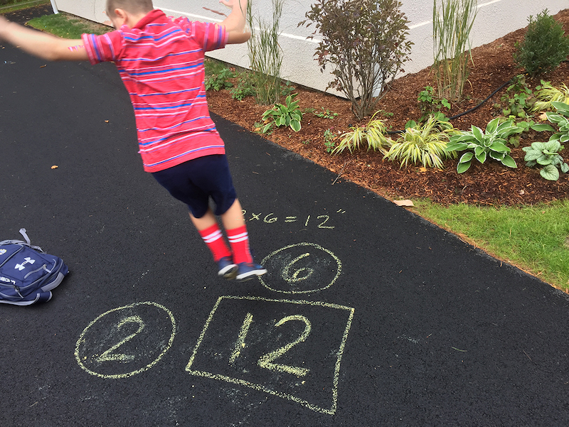 boy jumping on chalk squares with numbers