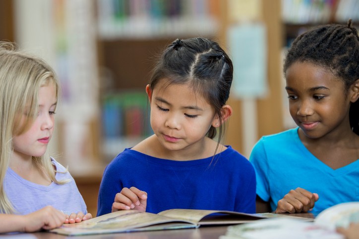 three girls looking at book