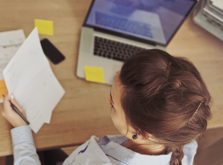 girl at computer with paper