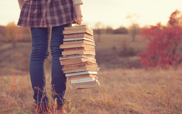 girl holding books in field