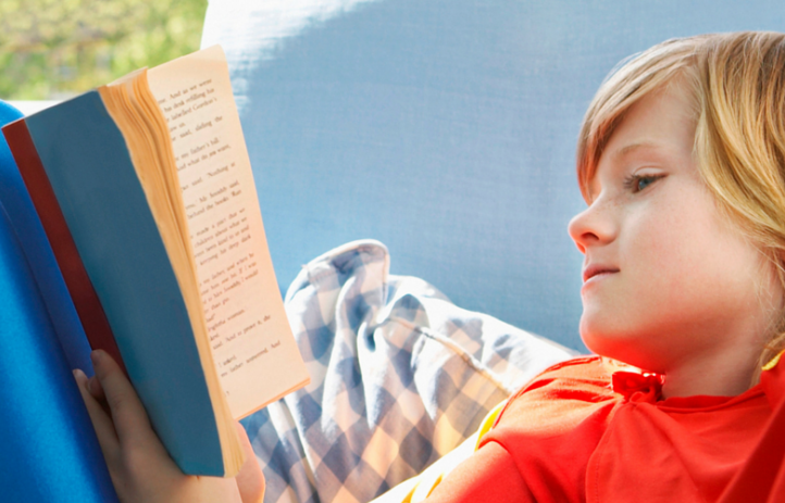 boy reading a book outside