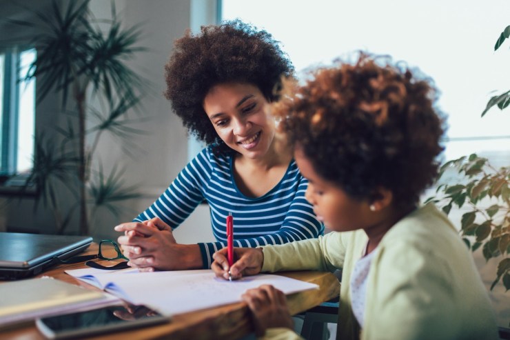 mother and son working on homework at table