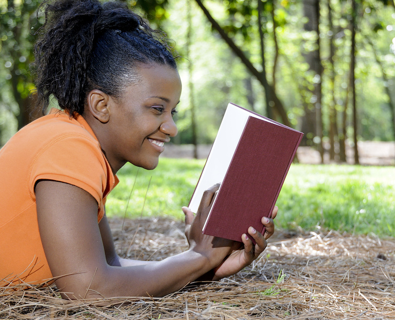 student reading a book outside