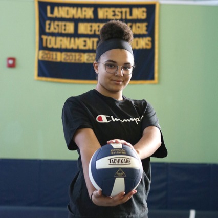 student holding volleyball