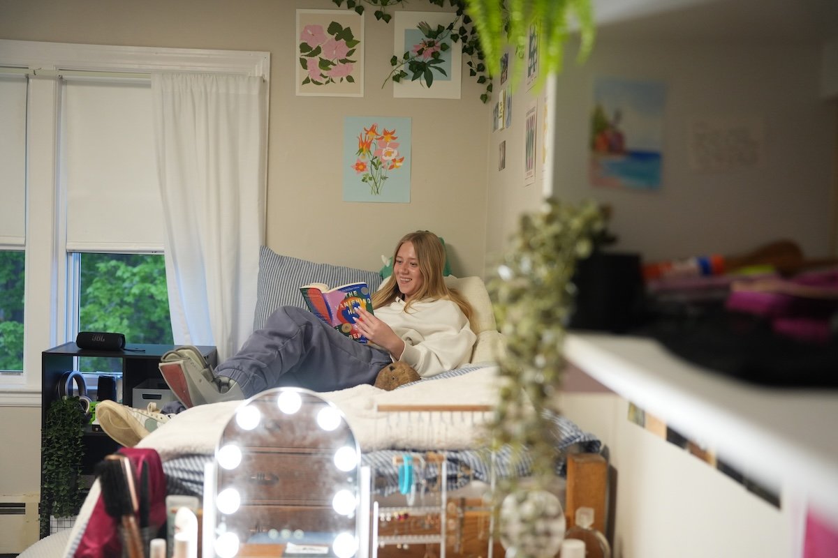 girl reading on bed in dorm