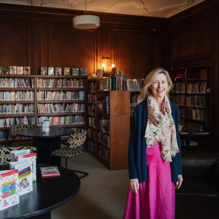 Linda Sylvester EMS Librarian standing in front of book stacks