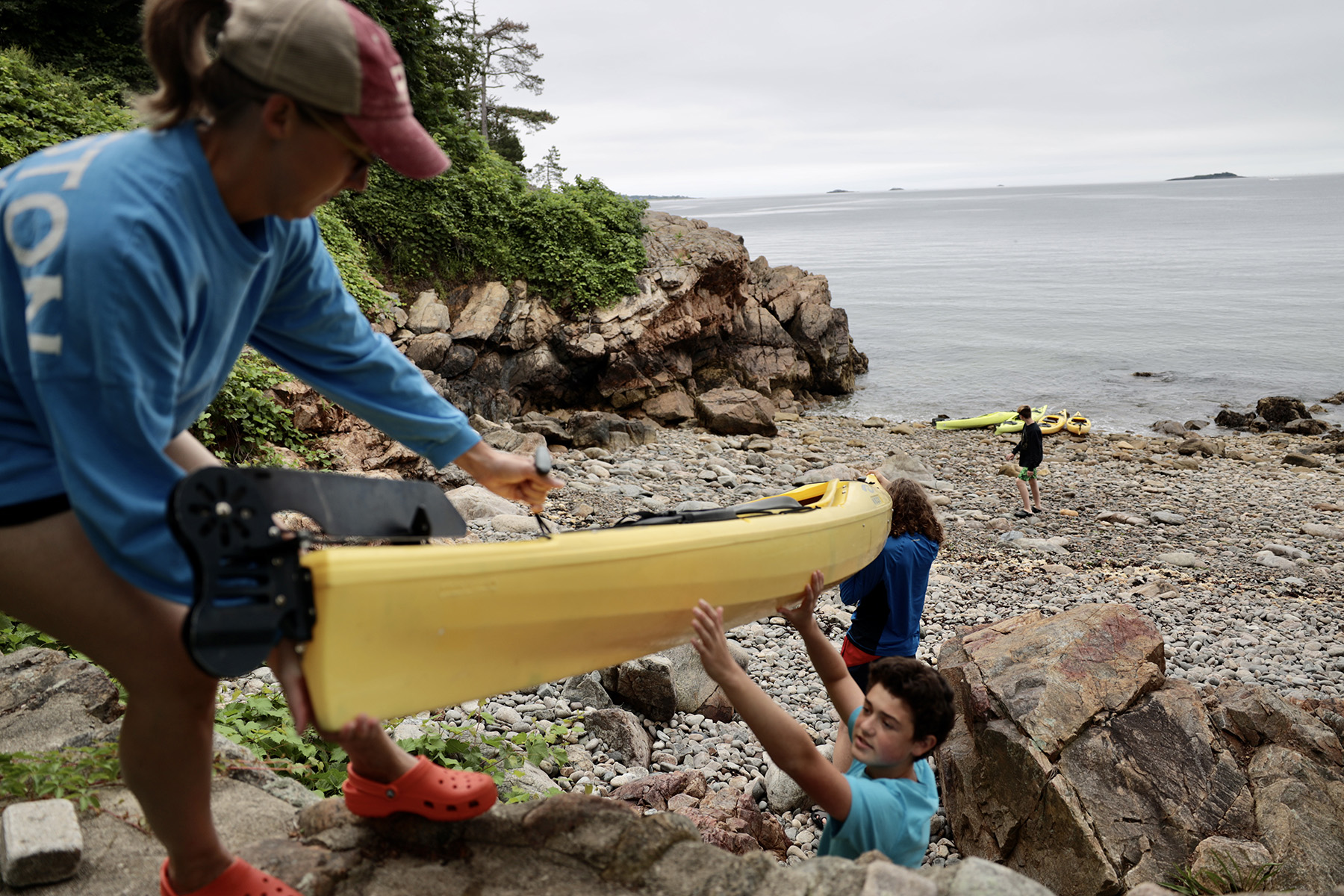 handing kayaks down to the beach